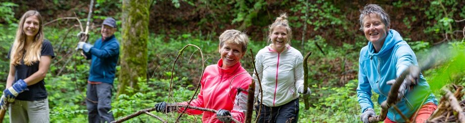 Natureinsatz Fünf fleissige Helfer schichten Äste zu einem grossen Asthaufen zusammen.